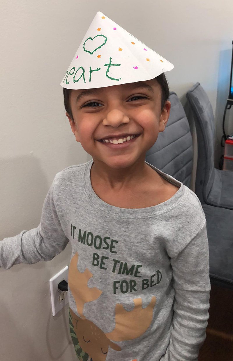 Picture of young child with a paper hat on their head