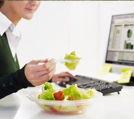 Person eating while working on computer